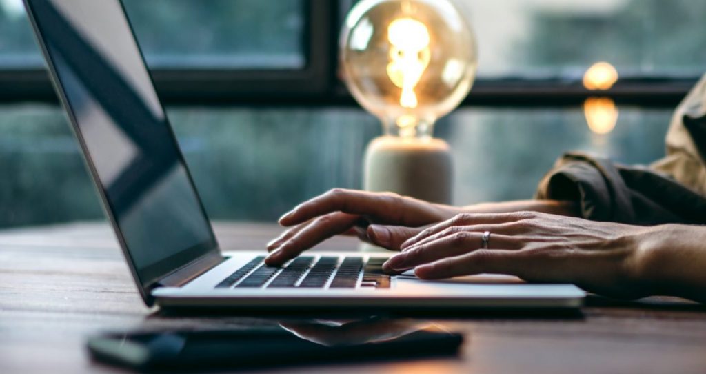 Person writing on laptop