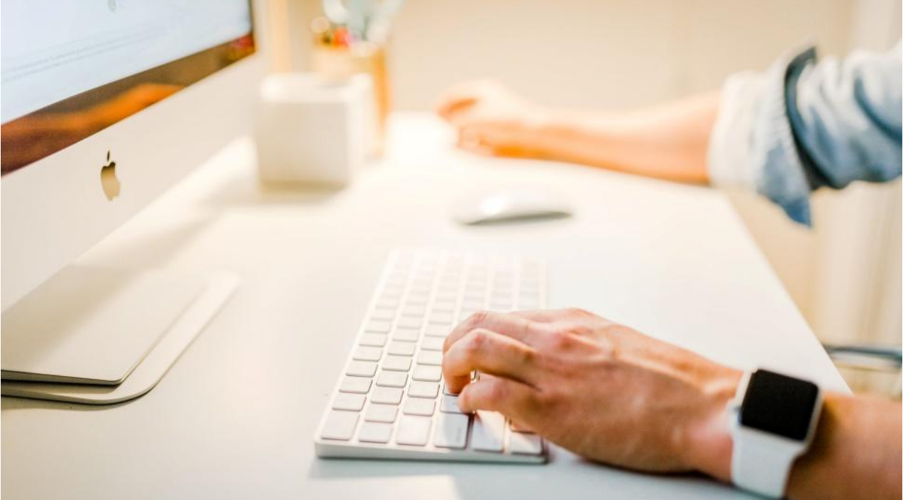 White laptop and person typing