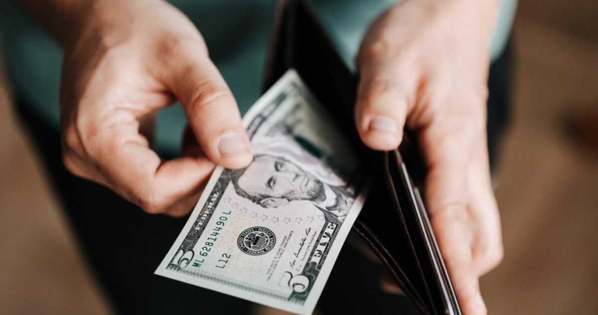 Unrecognizable man holding wallet with money