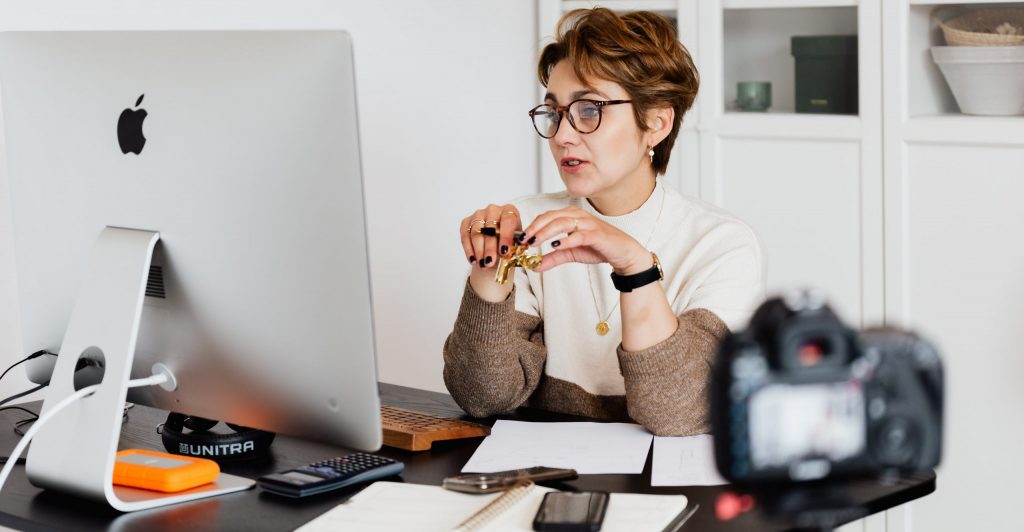 Confident elegant lady in eyeglasses hosting webinar