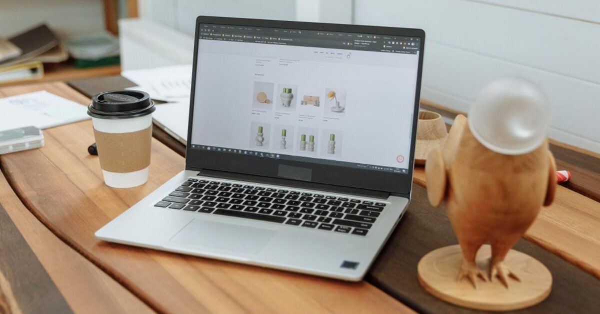 Laptop on a wooden table with the design business website on the screen