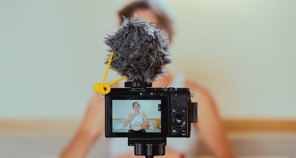 Shallow focus photo of a video camera recording an elderly woman