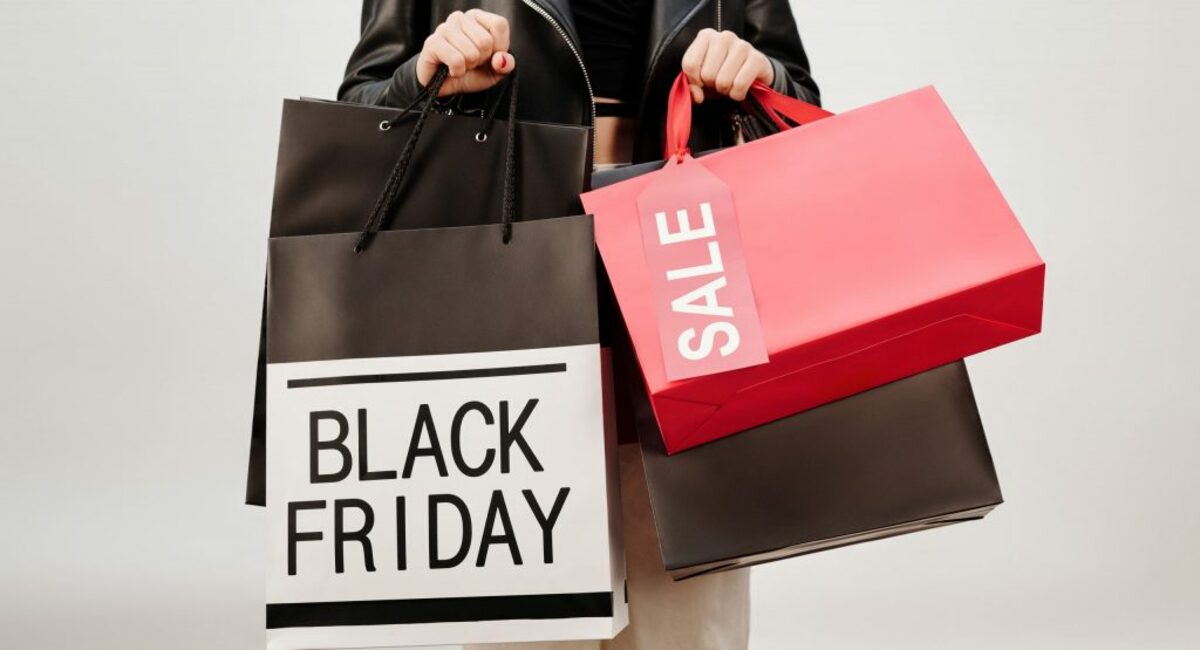 Woman in black leather jacket holding red and white box