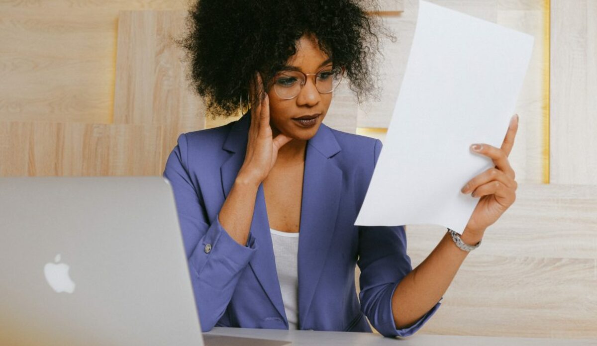 Woman in blue blazer holding white paper