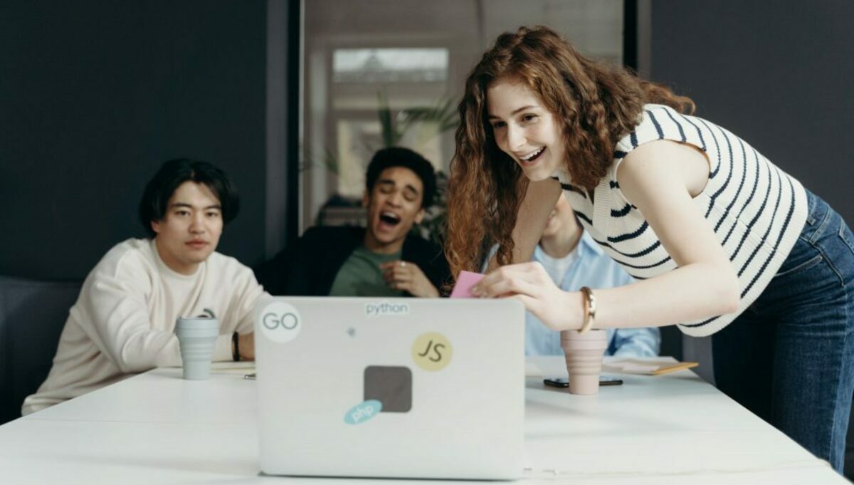 People laughing looking at a laptop