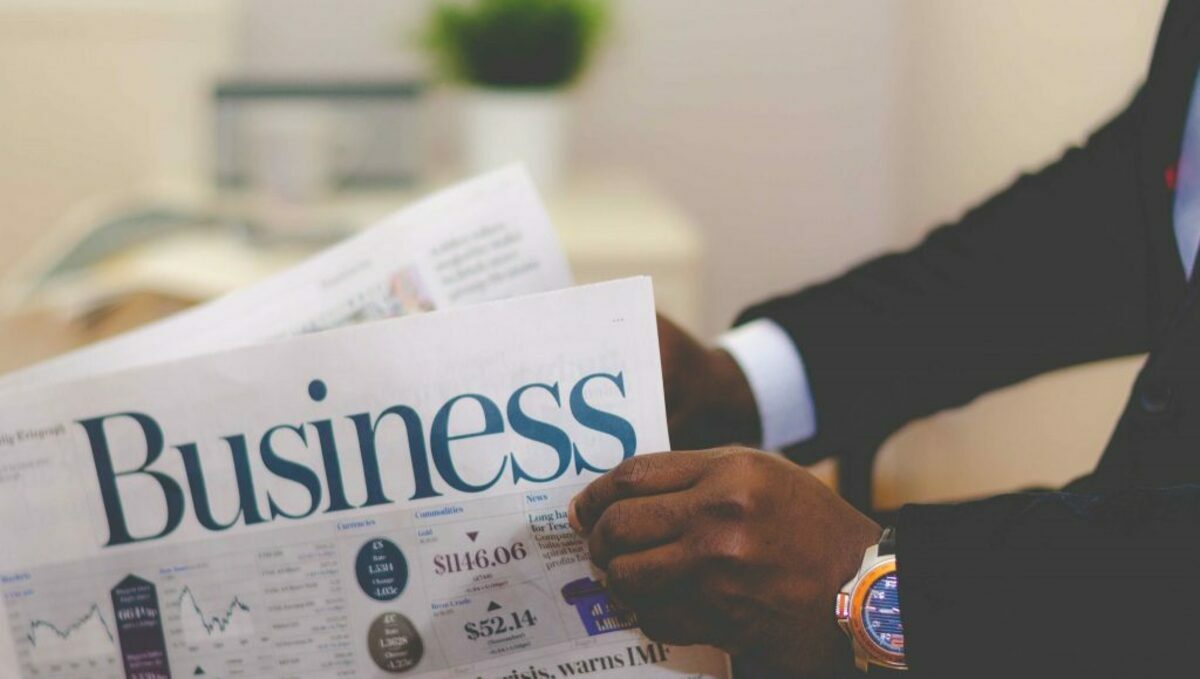 Person holding white and blue business paper