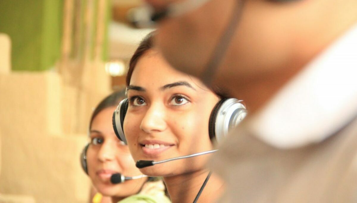 woman in black headphones holding black and silver headphones