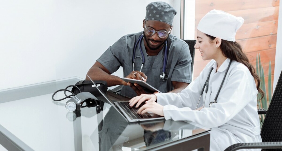 Man in blue scrub suit using laptop computer