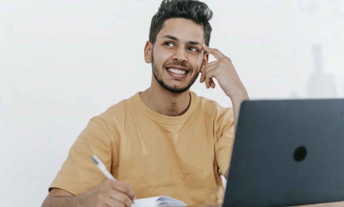 Dreamy ethnic businessman thinking about project