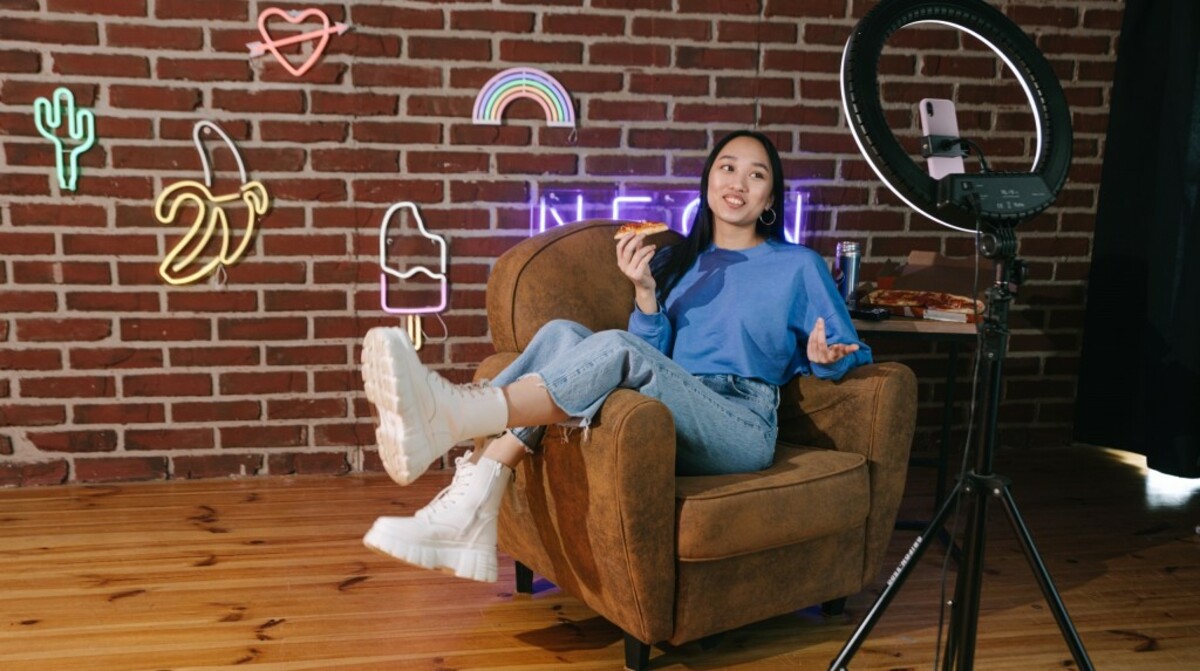 A woman recording herself with a smartphone while eating