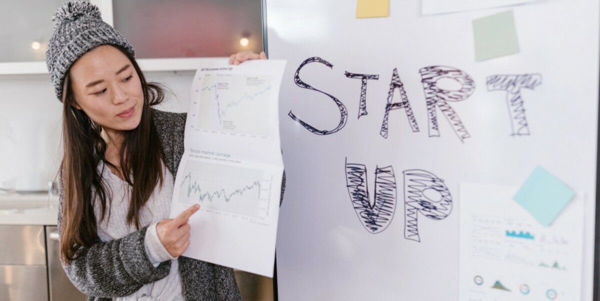 Woman holding white paper with graphs