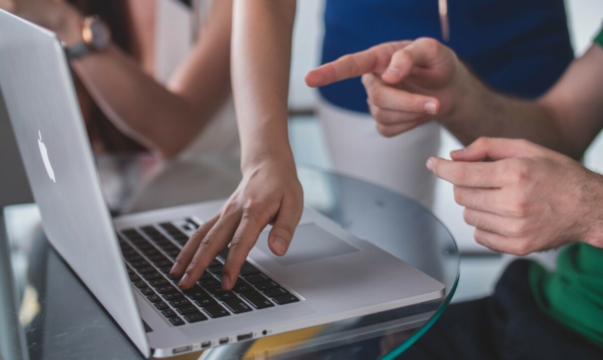 person touching and pointing MacBook Pro