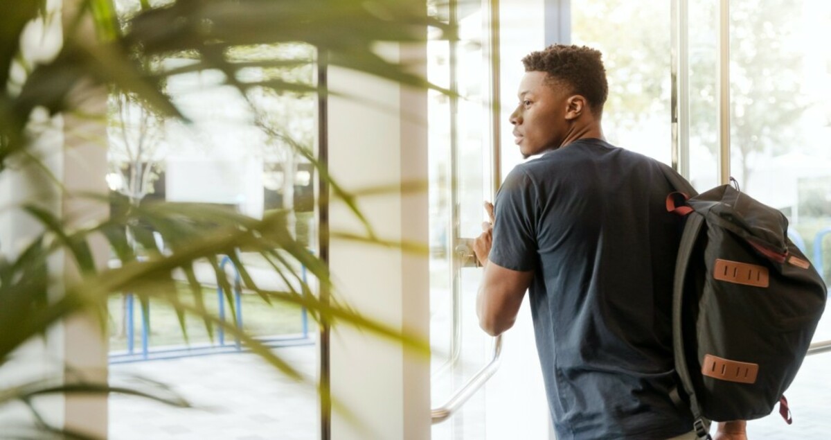 man holding glass door