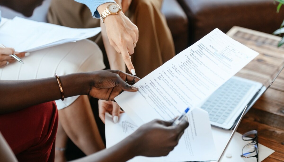 Multiethnic businesswomen checking information in documents