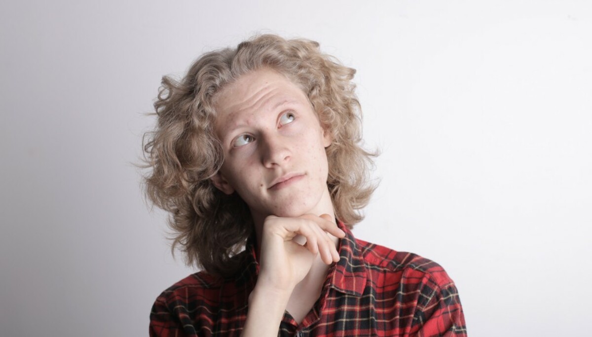 Pensive male teen on gray background