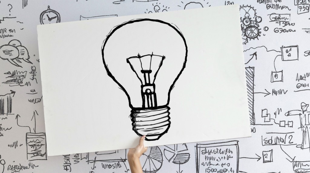 Woman draw a light bulb in white board